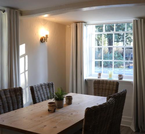 a dining room table with chairs and a window at The Lodge in Rempstone