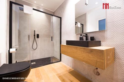 a bathroom with a shower and a toilet and a sink at Mazzini House by Holiday Home 24 in Genova
