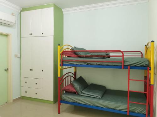 a room with two bunk beds and a closet at JMKT Homestay @ Bandar Seri Alam in Masai