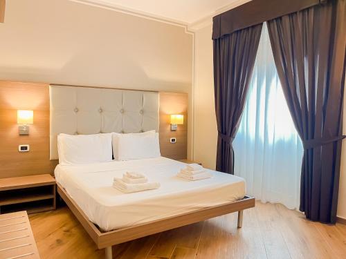 a bedroom with a bed with two towels on it at Brain Penthouse Pagani in Pagani