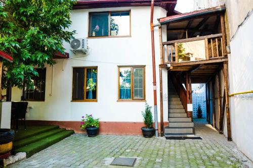 a white house with stairs and windows at HOSTEL SPORT BUCHAREST in Bucharest