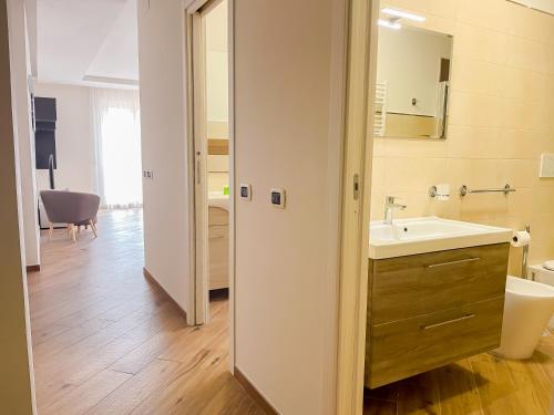 a bathroom with a sink and a toilet and a mirror at Brain Penthouse Pagani in Pagani