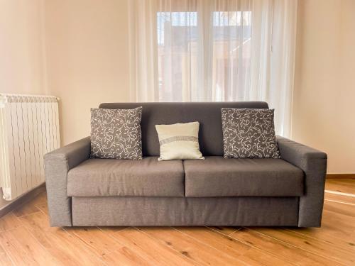 a gray couch with pillows in a living room at Brain Penthouse Pagani in Pagani
