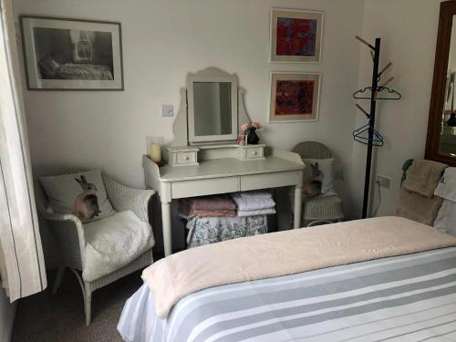 a bedroom with a bed and a desk and a mirror at The Guest Suite, Buttsfield Lane. in East Hoathly