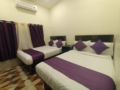 two beds in a room with purple and white at Hotel Star of Kurla - Nearest from Kurla - Near BKC in Mumbai