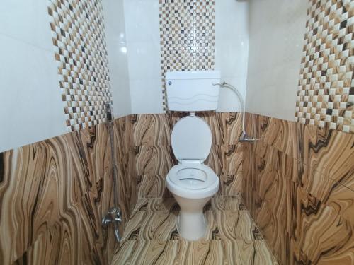 a bathroom with a toilet with wooden flooring at Hotel Star of Kurla - Nearest from Kurla - Near BKC in Mumbai