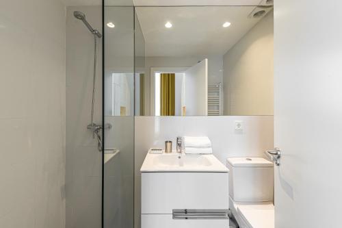 y baño blanco con lavabo y ducha. en BNBHolder Modern Loft I Centre, en Madrid