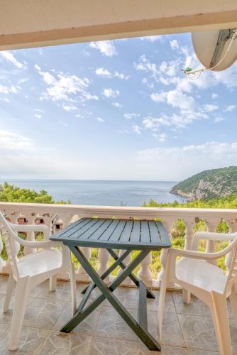 a table and chairs on a balcony with a view of the ocean at Snežna Kraljica in Sutomore