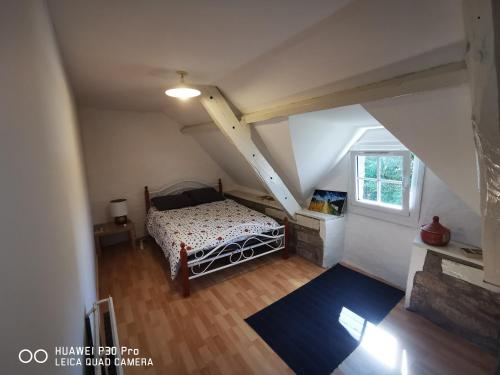 ein Schlafzimmer mit einem Bett im Dachgeschoss in der Unterkunft jolie longère dans un hameau de Bubry in Bubry