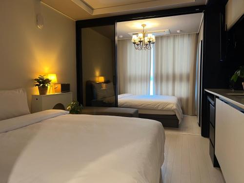 テグにあるAsh Mellowのベッド2台と鏡が備わるホテルルームです。