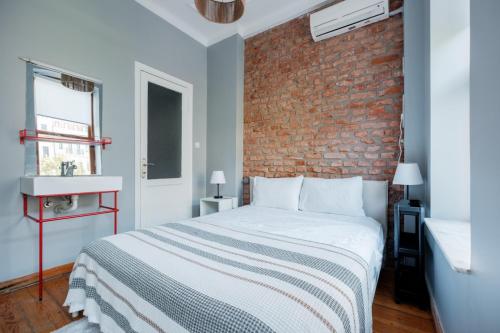 um quarto com uma cama e uma parede de tijolos em Rustic Stone Flat 5 min to Taksim Square em Istambul