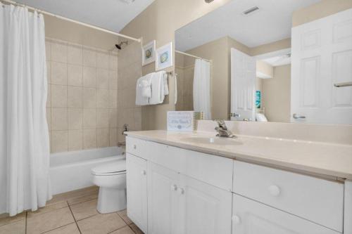 a white bathroom with a sink and a toilet at Majestic Sun 904B in Destin