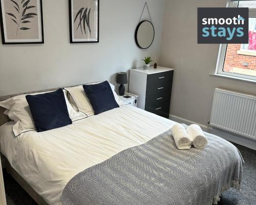 a bedroom with a bed with two towels on it at Modern 2 Bed Apartment By Smooth Stays Short Lets & Serviced Accommodation Preston With Parking Near Train Station in Preston