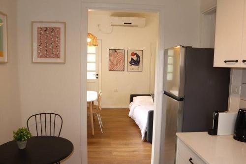 cocina con nevera y mesa en una habitación en Bright and Cozy Bauhaus Gem en Ra‘ananna
