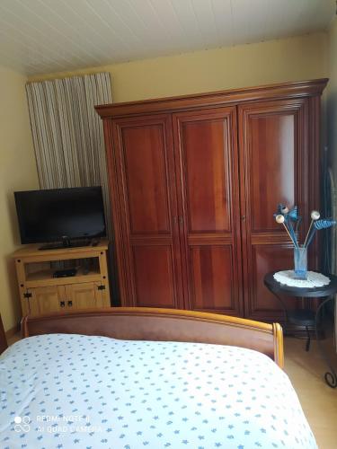 une chambre avec un lit et une armoire en bois dans l'établissement Ile Oléron Près du port de La Cotinière 2 pers. Plage et océan à 50 m, à Saint-Pierre-dʼOléron