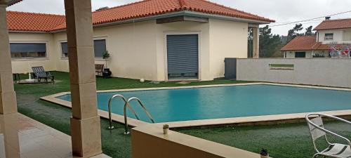 a swimming pool in the backyard of a house at Vale Poços House in Vinha da Rainha
