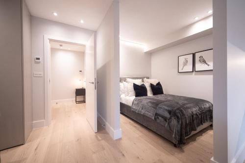 ロンドンにあるChic Studio w/ Balcony - Newly refurbishedの白いベッドルーム(ベッド1台付)、廊下