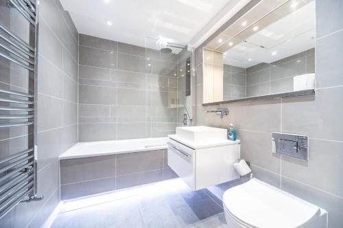 a white bathroom with a toilet and a sink at Chic Studio w/ Balcony - Newly refurbished in London