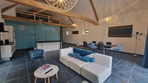 a living room with a white couch and a table at Le mas contemporain de Dun in Dun-le-Palestel