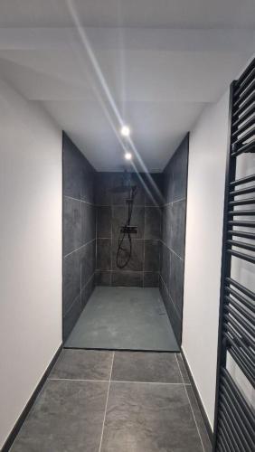 a bathroom with a shower with a tiled floor at Le mas contemporain de Dun in Dun-le-Palestel