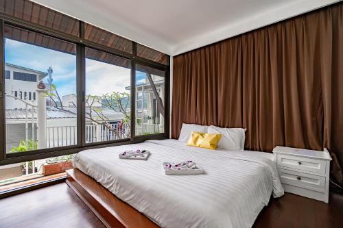 a bedroom with a large bed with two shoes on it at The Color Kata in Kata Beach