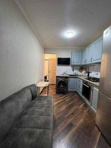 uma cozinha com armários azuis e um sofá num quarto em Naruto holiday home em Ranelagh
