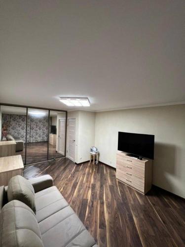 uma sala de estar com um sofá e uma televisão de ecrã plano em Naruto holiday home em Ranelagh