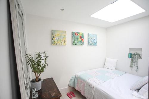 um quarto branco com uma cama e uma mesa em Stunning, architecturally designed Garden Studio with Parking em Londres