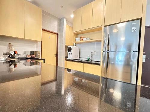 a kitchen with a stainless steel refrigerator and cabinets at The Floorspace Imperial Suites Apartment 2 in Kuching