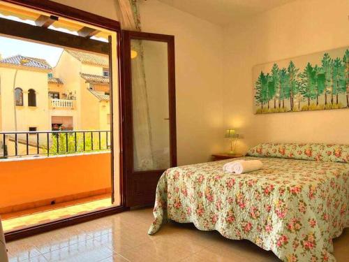 a bedroom with a bed and a sliding glass door at Casa Resort Mi Alcazar by SunshineClub in Los Alcázares