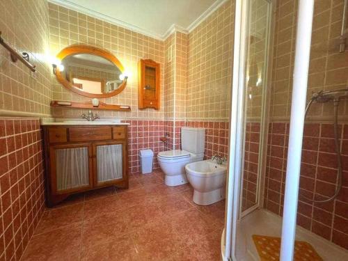 bagno con servizi igienici, lavandino e specchio di Casa Resort Mi Alcazar by SunshineClub a Los Alcázares