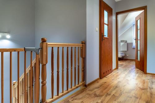 a hallway with a wooden staircase and a door at Dom Kotwa in Karwia
