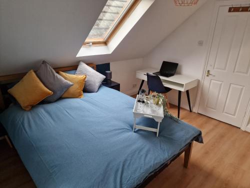 - une chambre avec un lit et un bureau avec un ordinateur portable dans l'établissement What a great location in Bromley with 4 bedrooms!, à Bromley