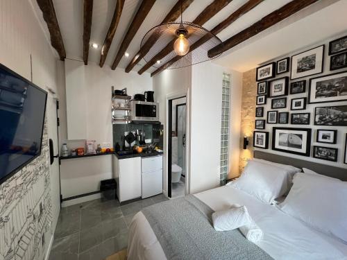 Cet appartement comprend une chambre avec un lit blanc et une cuisine. dans l'établissement Studios Pasteur- Paris XVe, à Paris