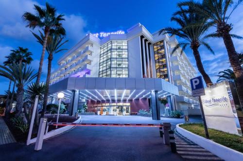 un hotel con palmeras frente a un edificio en Hotel Best Tenerife en Playa de las Américas