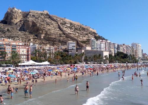 a crowd of people on a beach with buildings at Estudio Alicante Centro in Alicante