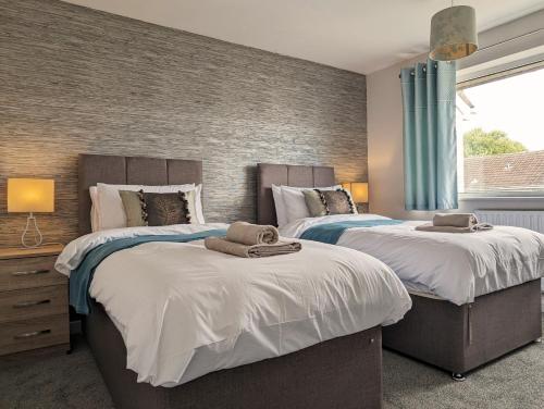 a bedroom with two beds with towels on them at Lavender View in Grantham