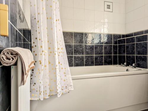 y baño con bañera y cortina de ducha. en Lavender View, en Grantham