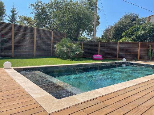 - une piscine dans un jardin avec une terrasse en bois dans l'établissement Chambre d'hôtes - VILLA PIERREDON, à Sanary-sur-Mer