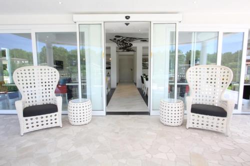 two chairs and two tables in front of a hallway at Ludwig Boutique Hotel & Spa in Bolsena
