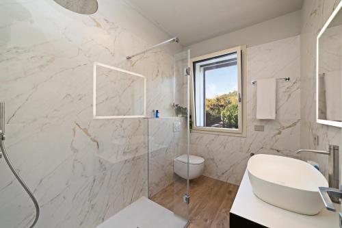 a bathroom with a shower and a toilet and a sink at LUXURY VILLA ORIZZONTI - Regarda Travel in Bardolino