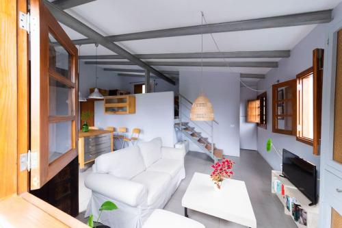 エルミグアにあるCasa Rural El Arenalの白いソファとテーブルのあるリビングルーム