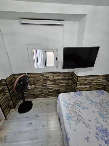 1 dormitorio con 1 cama y TV de pantalla plana en Habitación privada en Hospitalet de llobregat, en Hospitalet de Llobregat
