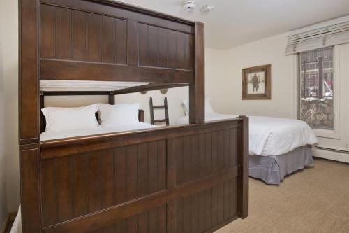 a bedroom with a bed and a large wooden headboard at Village Center 1-e in Vail