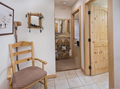 a wooden chair in a room with a door at Village Center 1-e in Vail