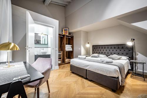 a bedroom with a large bed and a desk at Hs4U Ricasoli Luxury apartment near Duomo N.1 in Florence