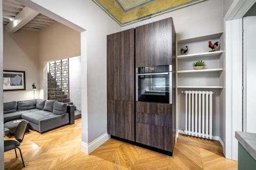 a living room with a couch and a microwave at Hs4U Ricasoli Luxury apartment near Duomo N.1 in Florence