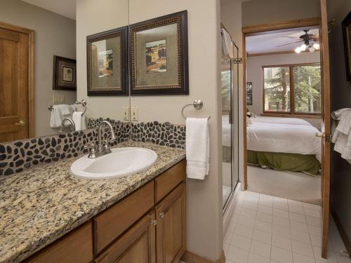 a bathroom with a sink and a bedroom at Arrowhead Village Condo - 104 Aspenwood Lodge in Edwards