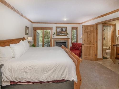 a bedroom with a large bed and a fireplace at Coldstream Townhome 19 in Vail