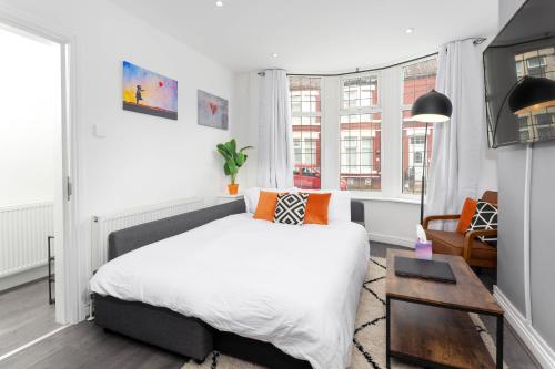 a bedroom with a large bed and a table at Flatzy - 12 Person Townhouse with Pool Table and Ping Pong in Liverpool